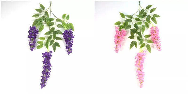 Faux wisteria flowers hanging from a white metal balcony railing